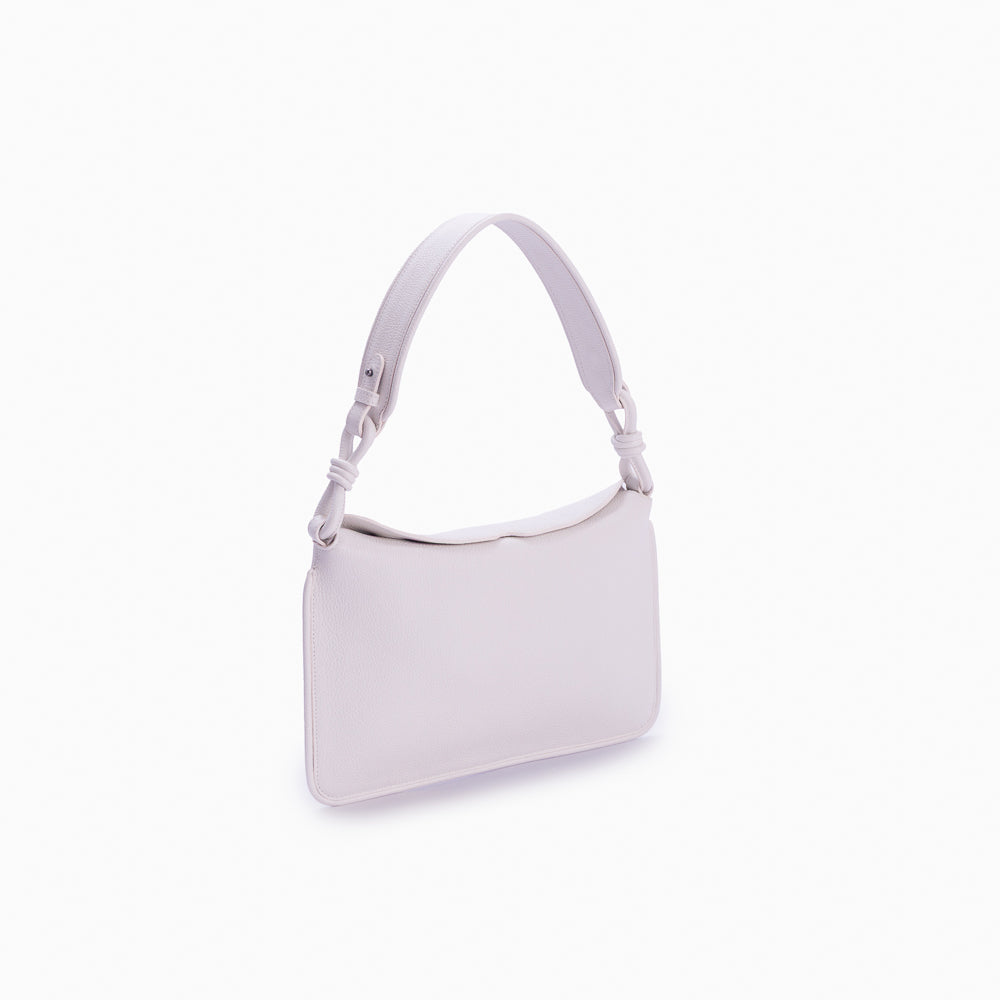 Flap Loop Soleah em couro off white: bolsa com aba frontal, formato compacto e alça longa para uso no ombro ou transversal; vista lateral em três quartos, mostrando profundidade, laterais, volume e construção da peça.