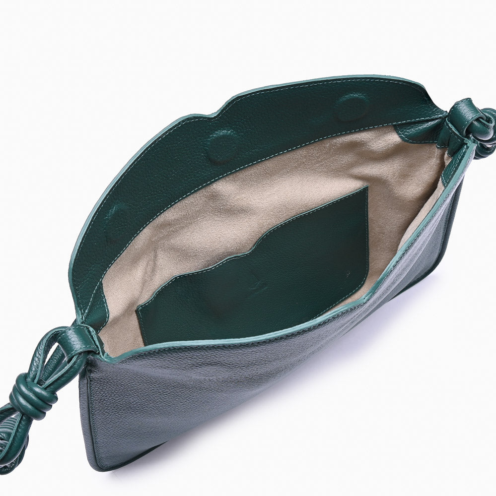 Flap Loop Soleah em couro verde: bolsa com aba frontal, formato compacto e alça longa para uso no ombro ou transversal; bolsa aberta em detalhe, mostrando o compartimento interno, o forro e o acabamento das bordas.