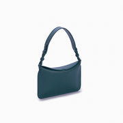 Flap Loop Soleah em couro verde: bolsa com aba frontal, formato compacto e alça longa para uso no ombro ou transversal; vista lateral em três quartos, mostrando profundidade, laterais, volume e construção da peça.