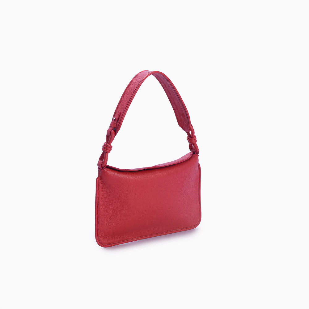Flap Loop Soleah em couro vermelha: bolsa com aba frontal, formato compacto e alça longa para uso no ombro ou transversal; vista lateral em três quartos, mostrando profundidade, laterais, volume e construção da peça.