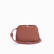 Handbag Loop Soleah em couro caramelo: bolsa de mão de formato compacto, com alça superior curta e acabamento de linhas orgânicas; vista frontal com a alça longa posicionada ao redor da bolsa, evidenciando a opção de uso no ombro ou transversal.