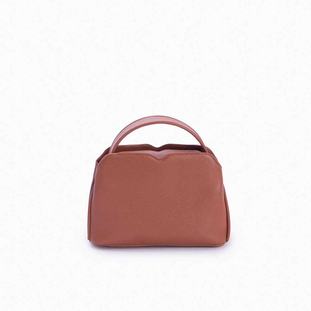 Handbag Loop Soleah em couro caramelo: bolsa de mão de formato compacto, com alça superior curta e acabamento de linhas orgânicas; vista frontal, destacando a silhueta, o acabamento do couro e os principais elementos externos.