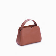 Handbag Loop Soleah em couro caramelo: bolsa de mão de formato compacto, com alça superior curta e acabamento de linhas orgânicas; vista lateral em três quartos, mostrando profundidade, laterais, volume e construção da peça.