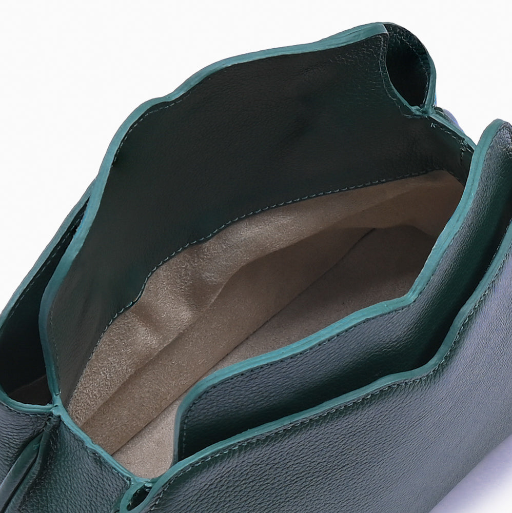 Handbag Loop Soleah em couro verde: bolsa de mão em couro de formato compacto, com alça superior curta e acabamento de linhas orgânicas; bolsa aberta em detalhe, mostrando o compartimento interno, o forro e o acabamento das bordas.