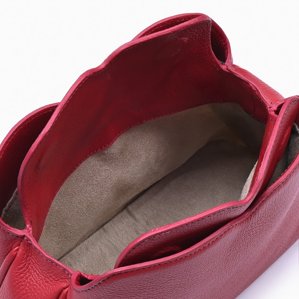 Handbag Loop Soleah em couro vermelha: bolsa de mão em couro de formato compacto, com alça superior curta e acabamento de linhas orgânicas; bolsa aberta em detalhe, mostrando o compartimento interno, o forro e o acabamento das bordas.