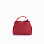 Handbag Loop Soleah em couro vermelha: bolsa de mão em couro de formato compacto, com alça superior curta e acabamento de linhas orgânicas; vista frontal, destacando a silhueta, o acabamento do couro e os principais elementos externos.