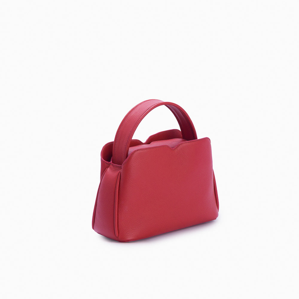 Handbag Loop Soleah em couro vermelha: bolsa de mão em couro de formato compacto, com alça superior curta e acabamento de linhas orgânicas; vista lateral em três quartos, mostrando profundidade, laterais, volume e construção da peça.
