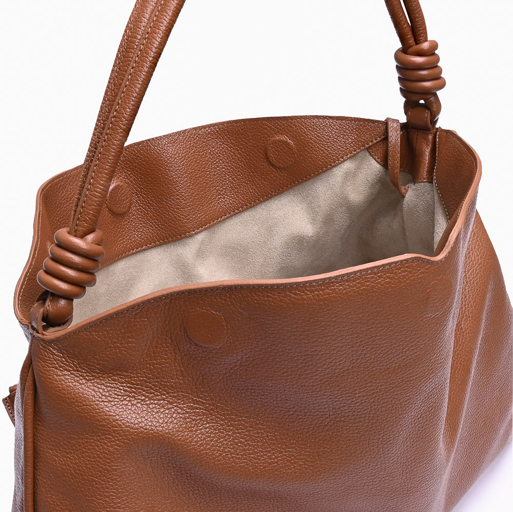 Hobo Loop Soleah em couro caramelo: bolsa hobo de formato macio e alongado, com alça de ombro e acabamento de linhas orgânicas; bolsa aberta em detalhe, mostrando o compartimento interno, o forro e o acabamento das bordas.