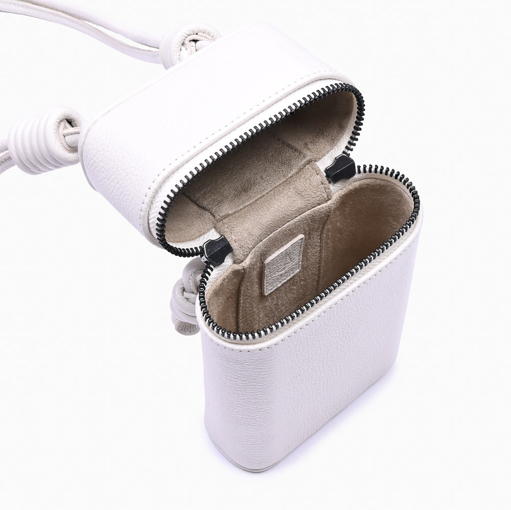 Estojo Loop Soleah em couro off white: estojo compacto, com formato retangular e alça curta para transporte; estojo aberto em detalhe, mostrando o espaço interno, o forro e o acabamento das bordas.